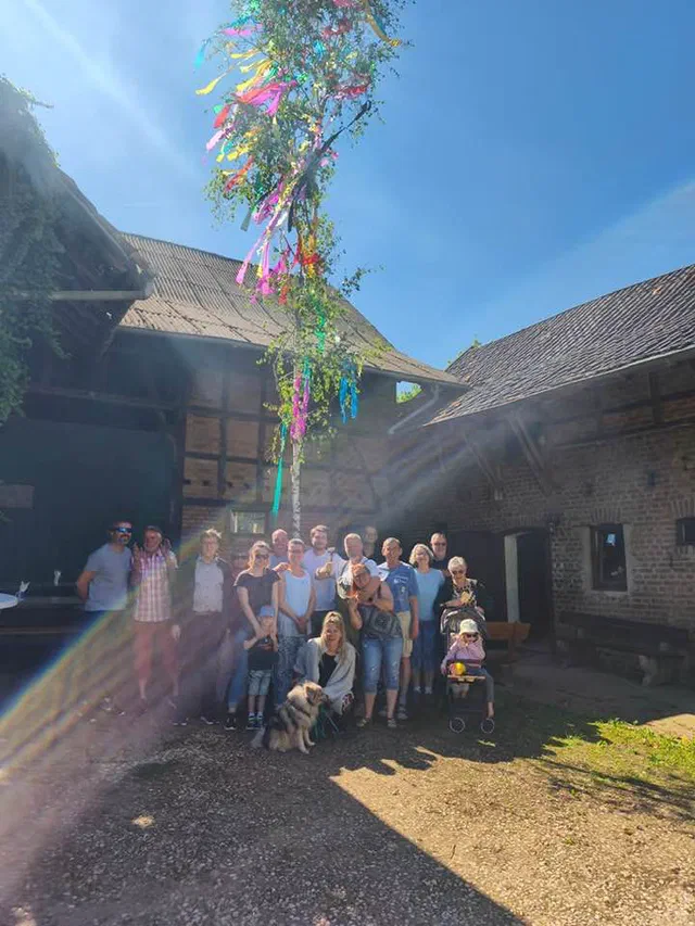 Gruppenbild unter dem geschmückten Maibaum am Dorfstall