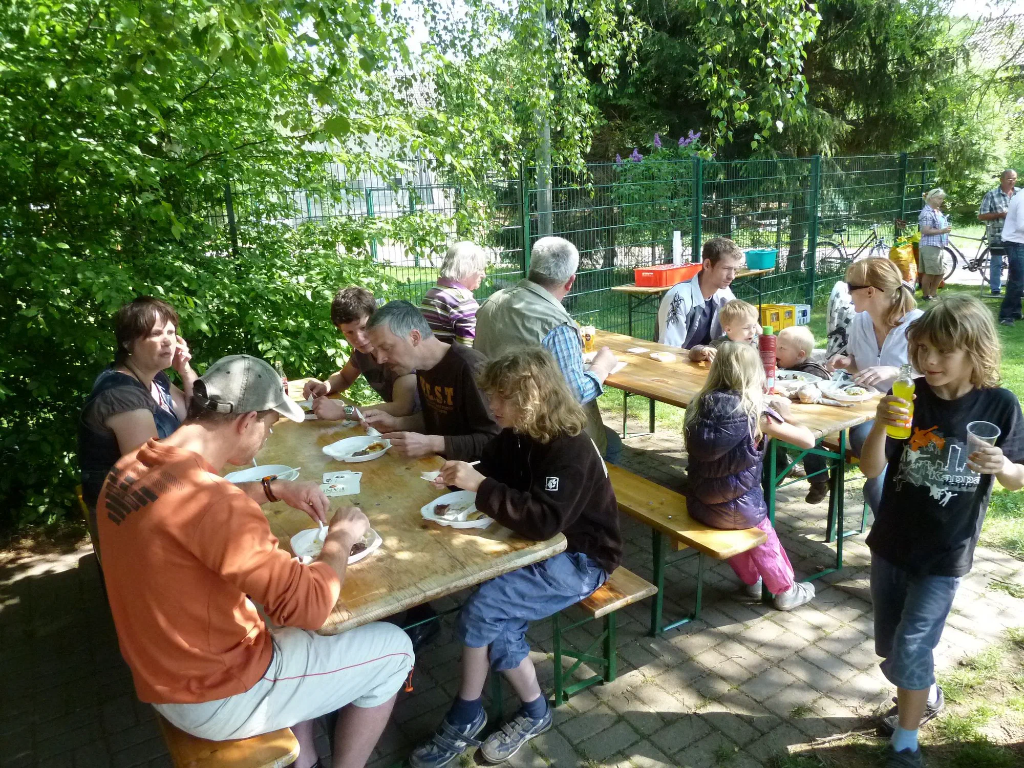 Gäste an Biertischen beim Sommerfest